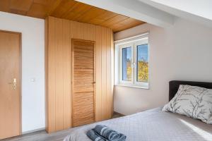 バート・ヘルスフェルトにあるFewo am Stadtrand von Bad Hersfeldのベッドルーム1室(ベッド1台、木製クローゼット付)