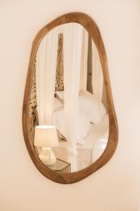 a mirror hanging on a wall with a bed at Villa Calma by A&D Properties in Porto Rafti