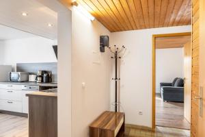 バート・ヘルスフェルトにあるFewo am Stadtrand von Bad Hersfeldの白い壁と木製の天井のキッチン