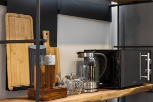 a kitchen counter with a coffee maker and a microwave at Svyvo Cologne-Esch Design Apartment in Cologne +43 photos
