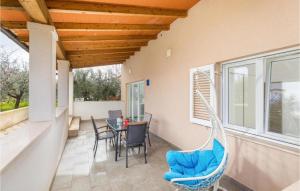 um pátio com uma mesa, cadeiras e uma rede de descanso em Apartman Topolino em Vodnjan