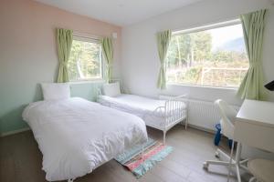 a bedroom with two beds and a window at Grey House Niseko in Niseko