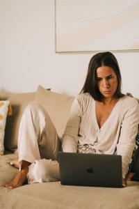 a woman sitting on a couch with a laptop at Villa Calma by A&D Properties in Porto Rafti