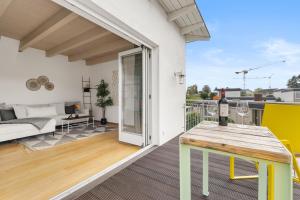 a balcony with a table with a wine bottle on it at Svyvo Cologne-Esch Design Apartment in Cologne