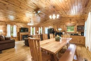 a wooden dining room with a wooden table and chairs at Charming Log Cabin with a Fire Pit in the Woods near Lake Logan in Ohio in Cedar Grove