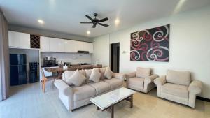 ジンバランにあるThe BALIem Villaのソファと椅子、キッチンのあるリビングルーム
