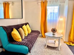 a living room with a couch and a table at Sunny Suite by Leslodgespa - Studio moderne et coloré, proche de Bâle et de l'aéroport in Blotzheim +19 photos