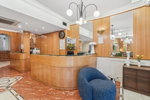 ein Salon mit Rezeptionstresen und einem blauen Stuhl in der Unterkunft Hotel Le Clery in Paris + 32 Fotos