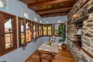 una habitación con ventanas y una mesa con una planta en Αρχοντικό 1716, en Agios Lavredios 23 fotos más