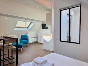 a room with a bed and a table and chairs at Wellness Suite Ponsardin 3 - Reims Centre in Reims