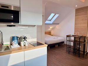 a kitchen with a sink and a bed in a room at Wellness Suite Ponsardin 3 - Reims Centre in Reims