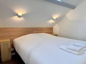 a bedroom with a white bed with towels on it at Wellness Suite Ponsardin 3 - Reims Centre in Reims