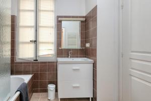 ein Badezimmer mit Waschbecken und Spiegel in der Unterkunft Au Cœur De Guérande - Intra Muros in Guérande + 15 Fotos