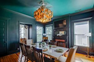 a dining room with a table and chairs and a chandelier at 6br New Orleans Speakeasy Hot Tub & Playground in Louisville
