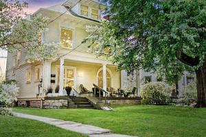 a white house with a porch and a lawn at 6br New Orleans Speakeasy Hot Tub & Playground in Louisville