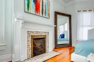 a living room with a fireplace and a mirror at 6br New Orleans Speakeasy Hot Tub & Playground in Louisville