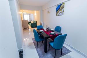 a dining room with a table and blue chairs at Luxurious Nairobi Apartment with City and Garden Views in Nairobi