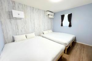 two beds in a room with white sheets at OKINAWA POOLWILLA ONNA 4A - Vacation STAY 48422v in Baba