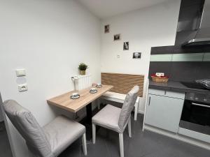 a small kitchen with a wooden table and chairs at Apartment Mira 12 in Pulheim