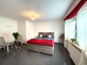 a bedroom with a bed with a red blanket at Apartment Mira 12 in Pulheim