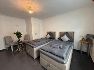 a bedroom with two beds and a table and a chair at Apartment Mira 12 in Pulheim +4 photos