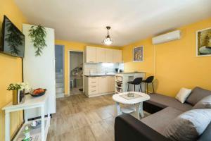 a living room with a couch and a table and a kitchen at Apartment in Crikvenica 41694 in Sopaljska