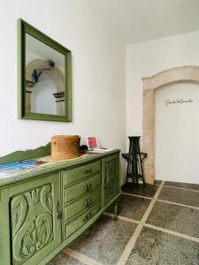 a green dresser in a room with a mirror at Janelas do Governador in Elvas