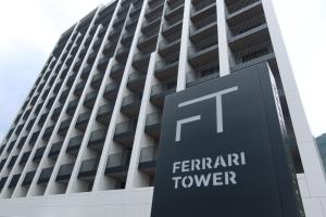 博尔扎诺Ferrari Tower的一座带有蕨岸塔标志的建筑物