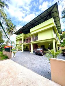 a yellow building with a car parked in front of it at Radhika Residency in Perintalmanna