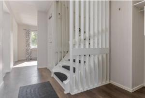 Una escalera blanca en una habitación blanca con alfombra en Day To Day Motel, en Ludvika