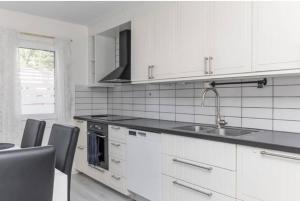 a white kitchen with a sink and a stove at Day To Day Motel in Ludvika