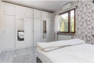 a white bedroom with a bed and a window at Day To Day Motel in Ludvika