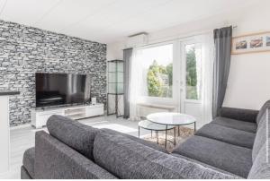 Una sala de estar con un sofá y un televisor. en Day To Day Motel, en Ludvika