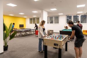 Eine Gruppe von Leuten spielt Tischfußball. in der Unterkunft Ferrari Tower in Bozen