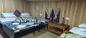 大吉岭Shubh Aagaman Homestay的一间卧室配有两张床、一张桌子和一张床 更多3张照片