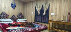 大吉岭Shubh Aagaman Homestay的一间卧室，里面有一张床、一张桌子和一扇窗户