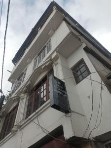 大吉岭Shubh Aagaman Homestay的一栋白色建筑，侧面有一块招牌