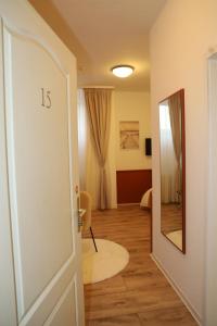 um corredor com uma porta e um espelho num quarto em Hotel Mutter Buermann em Hemmingen