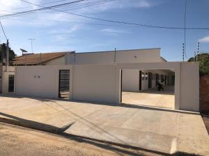 a white house with a garage in front of it at Apartamento em Sinop 11 in Sinop