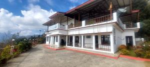 a large white building with balconies on top of it at Hotel Dream House in Kanatal