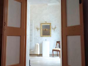 een open deur naar een kamer met een stoel en een spiegel bij La casa di Hermes in Imola