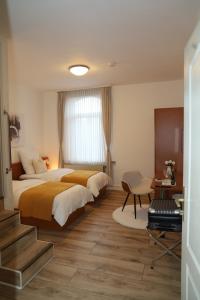 um quarto de hotel com duas camas e uma escada em Hotel Mutter Buermann em Hemmingen