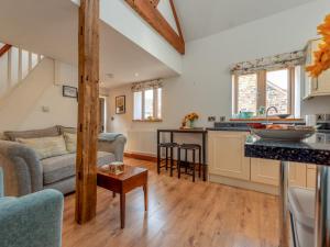 a kitchen and living room with a couch and a table at Pass the Keys Charming Granary Escape Garden Countryside in Much Wenlock