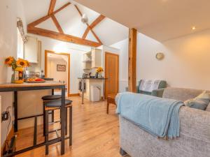 a kitchen and living room with a couch and a table at Pass the Keys Charming Granary Escape Garden Countryside in Much Wenlock +24 photos