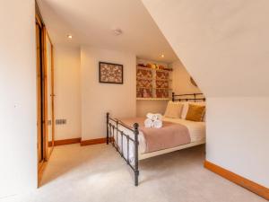 a bedroom with a bed and a staircase at Pass the Keys Charming Granary Escape Garden Countryside in Much Wenlock