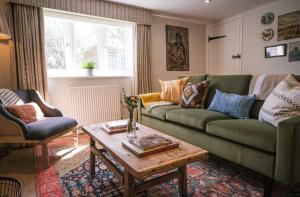 Apsley Cottage في Trotton: غرفة معيشة مع أريكة خضراء وطاولة قهوة