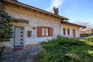a house with a white door and wooden windows at bed an breakfast Aurora in Trento