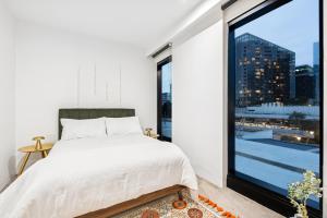 ein Schlafzimmer mit einem Bett und einem großen Fenster in der Unterkunft Luxury Marina Tower Stay Waterfront & City Views in Melbourne + 44 Fotos