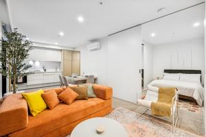 ein Wohnzimmer mit Sofa und Bett in der Unterkunft Luxury Marina Tower Stay Waterfront & City Views in Melbourne