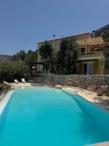 a large blue swimming pool in front of a house at Melolia Estate in Thiva